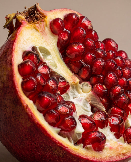 Notas de Dark Pomegranate: uma romã aberta com sementes cor de rubi