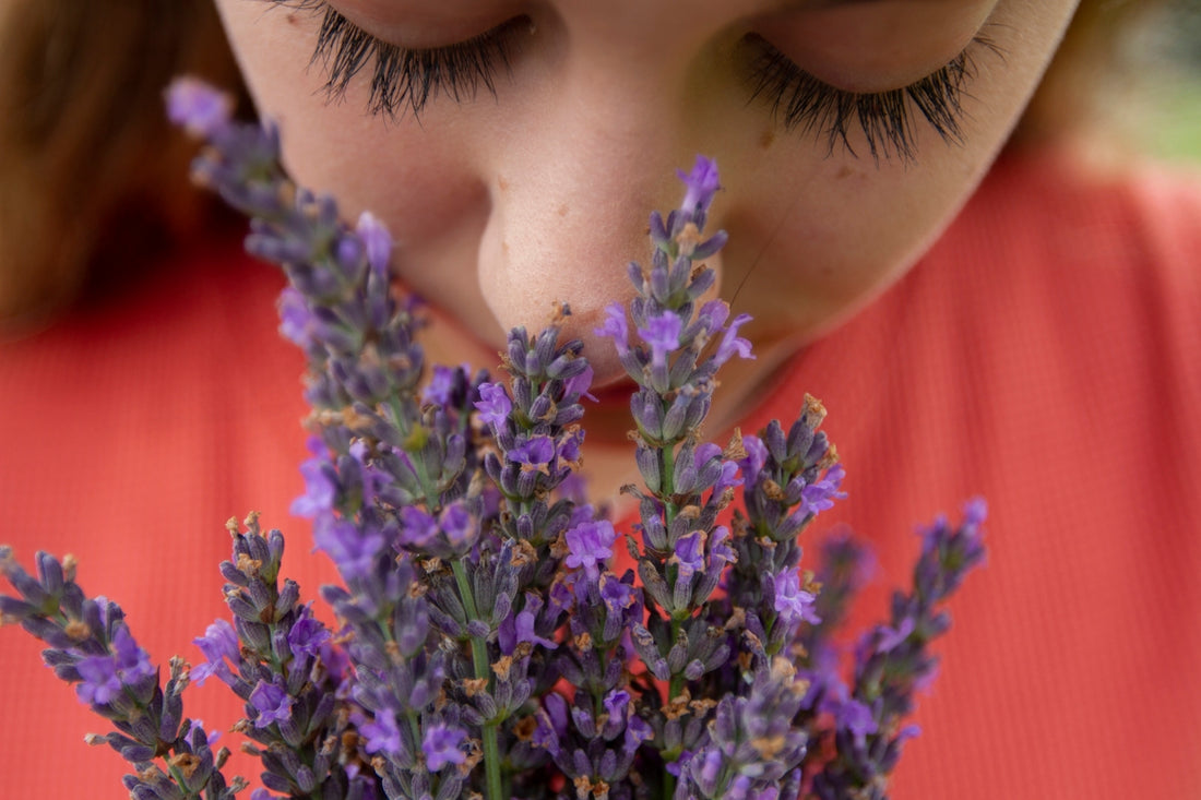 woman in orange shirt with purple flowers on her head