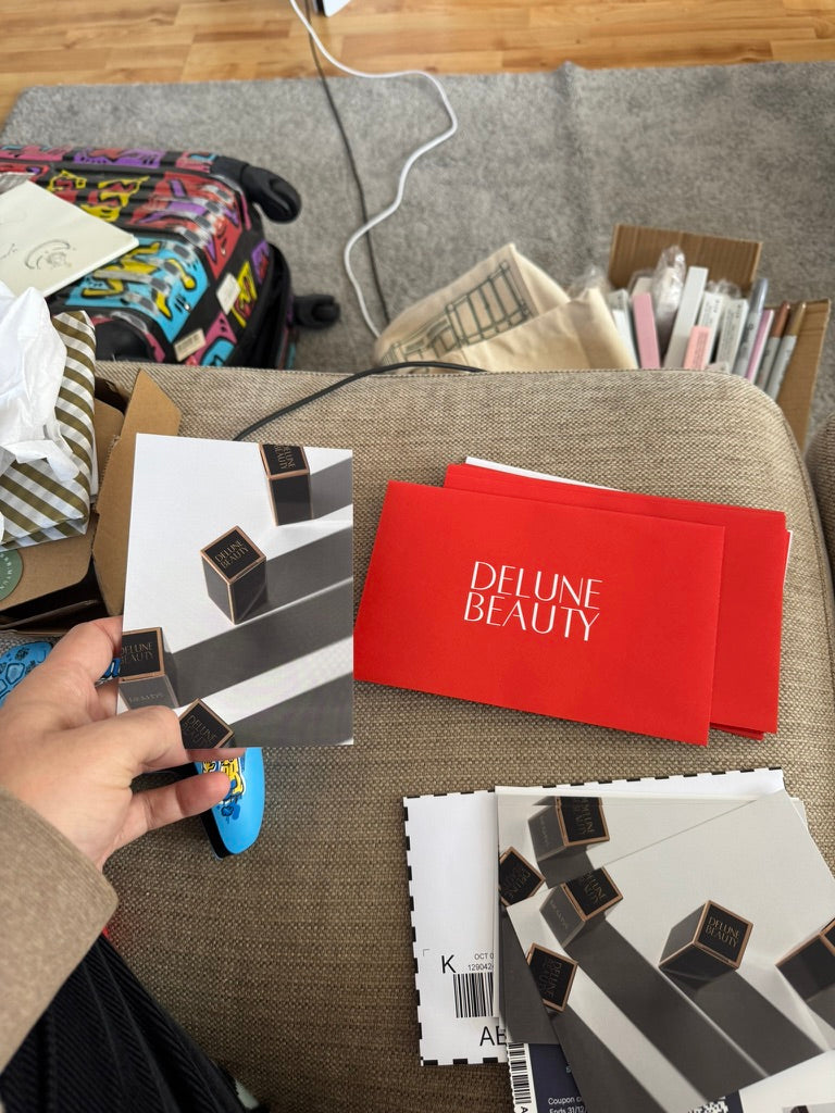 Cartões impressos da Delune Beauty e envelopes vermelhos prontos para embalar
