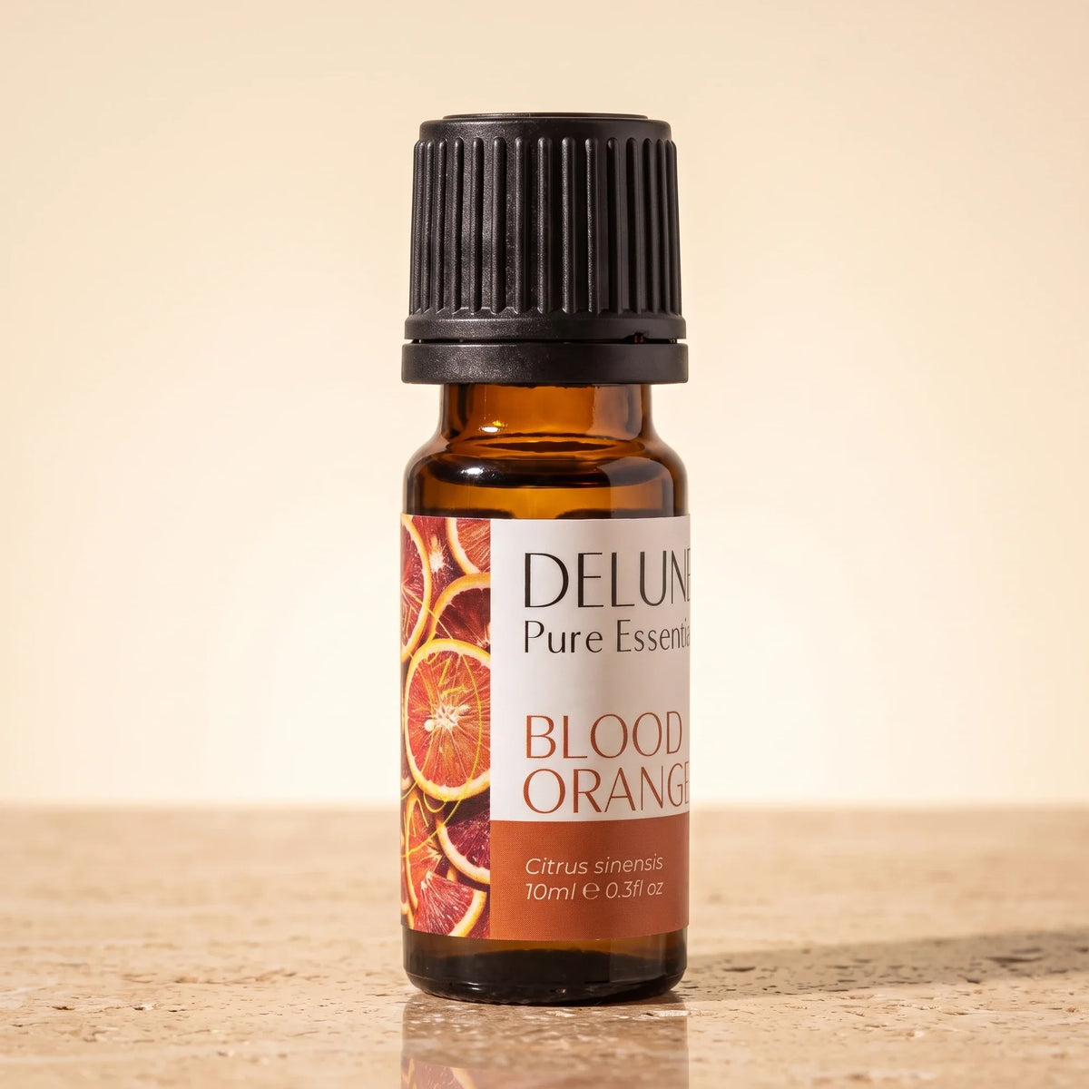 Óleo essencial puro de laranja-sanguínea Delune, frasco âmbar de 10 ml sobre travertino quente