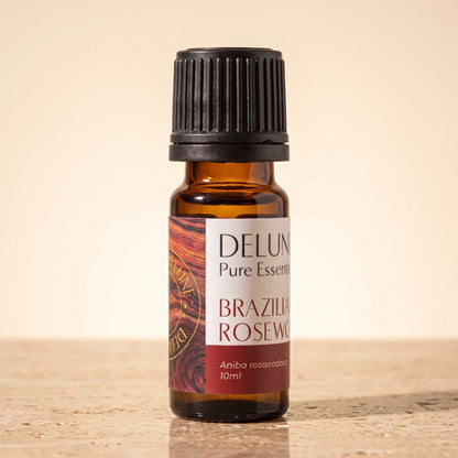 Óleo essencial puro de pau-rosa brasileiro Delune, frasco âmbar de 10 ml sobre travertino quente