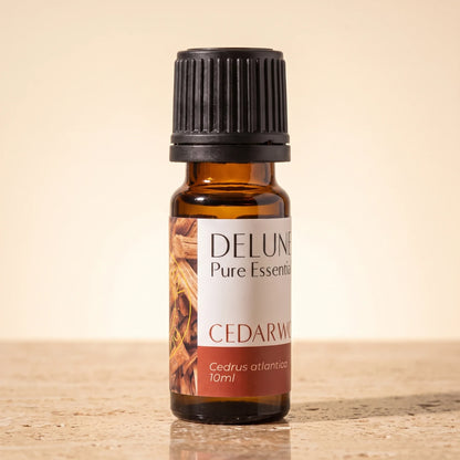 Óleo essencial puro de cedro Delune, frasco âmbar de 10 ml sobre travertino quente