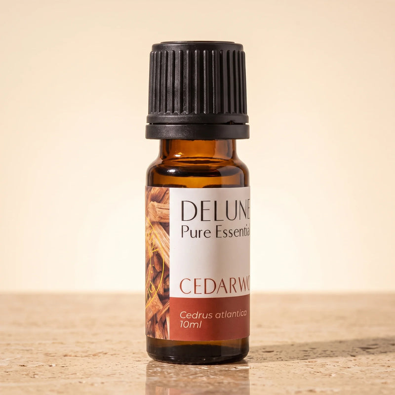 Óleo essencial puro de cedro Delune, frasco âmbar de 10 ml sobre travertino quente