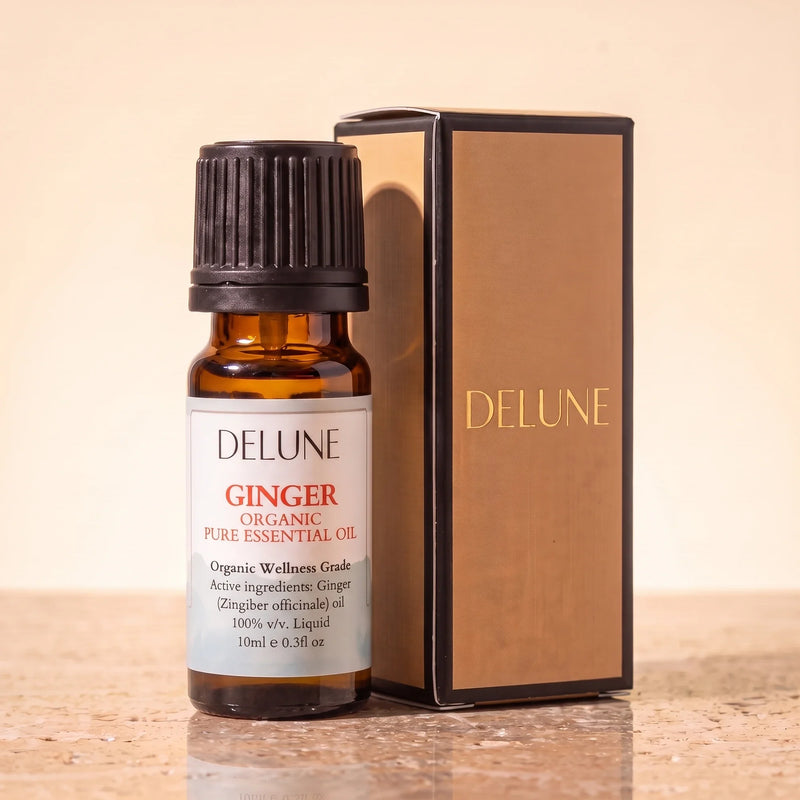 Óleo essencial orgânico de gengibre Delune, frasco âmbar de 10 ml com a caixa de presente dourada Delune sobre travertino quente