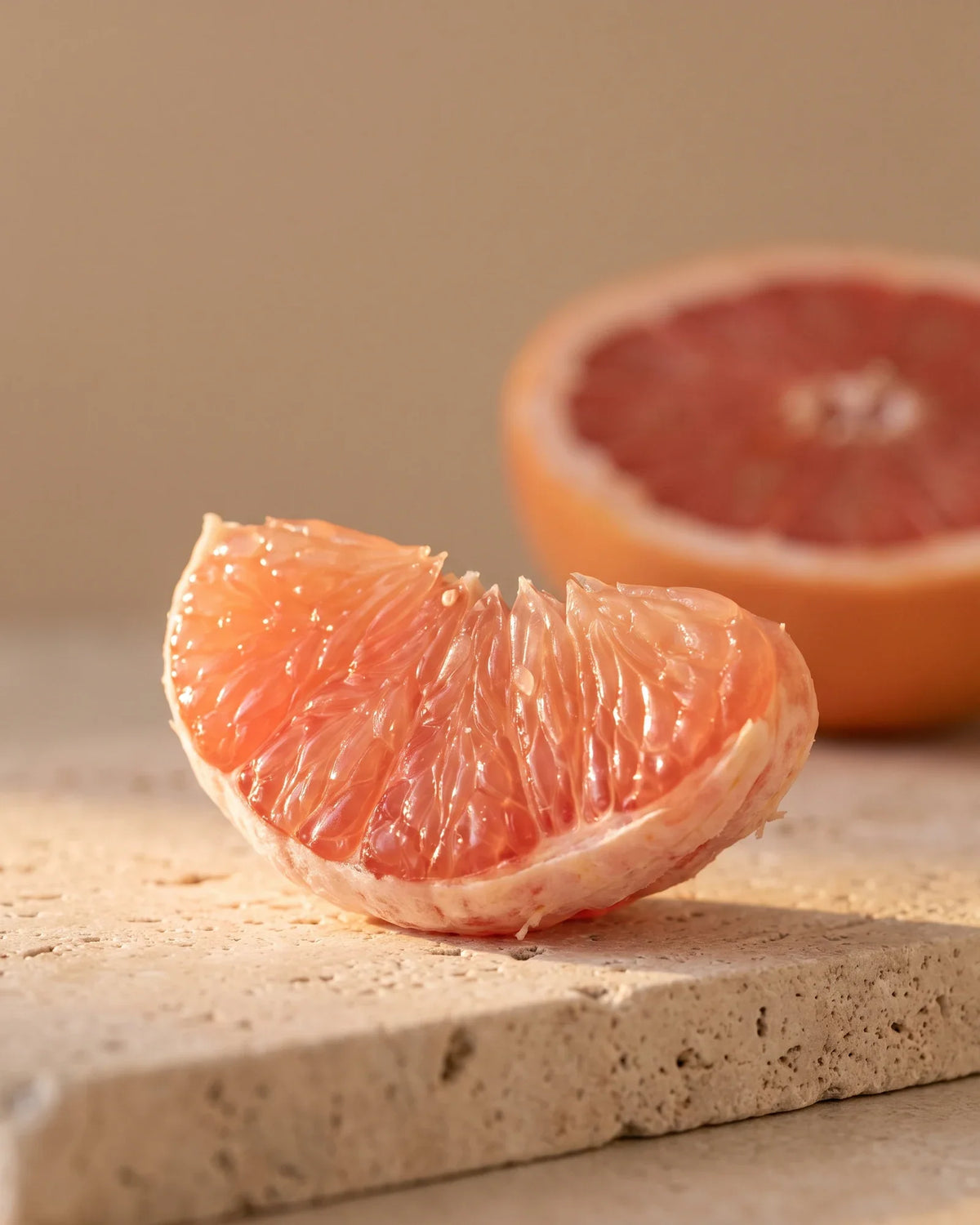Um gomo reluzente de toranja-rosa à contraluz do sol quente — o aroma agridoce e suculento do Óleo essencial puro de toranja-rosa Delune