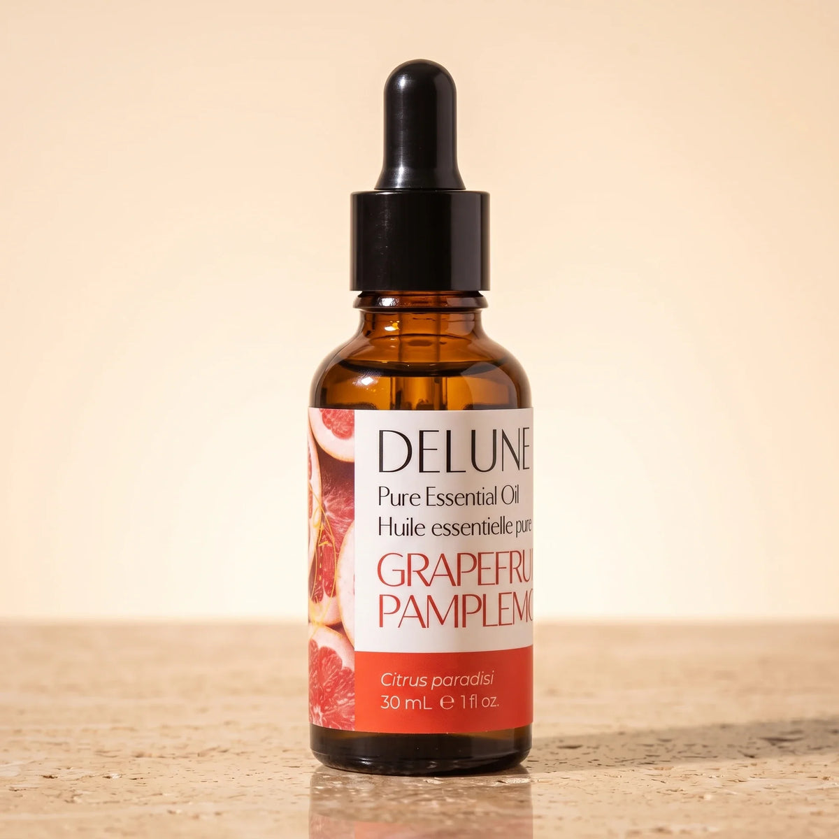Óleo essencial puro de toranja-rosa Delune, frasco âmbar conta-gotas de 30 ml sobre travertino quente