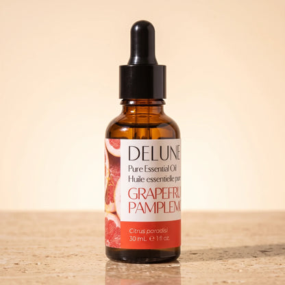 Óleo essencial puro de toranja-rosa Delune, frasco âmbar conta-gotas de 30 ml sobre travertino quente