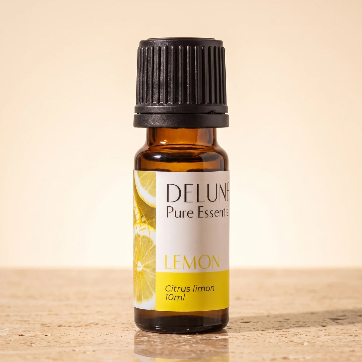 Óleo essencial puro de limão Delune, frasco âmbar de 10 ml sobre travertino quente