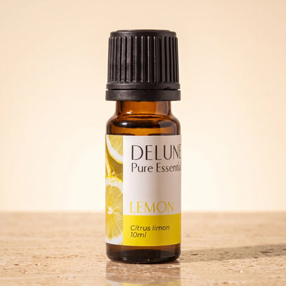 Óleo essencial puro de limão Delune, frasco âmbar de 10 ml sobre travertino quente