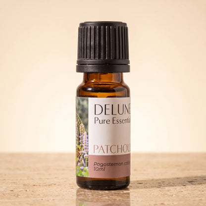Óleo essencial puro de patchouli Delune, frasco âmbar de 10 ml sobre travertino quente