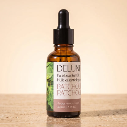 Óleo essencial puro de patchouli Delune, frasco âmbar conta-gotas de 30 ml sobre travertino quente