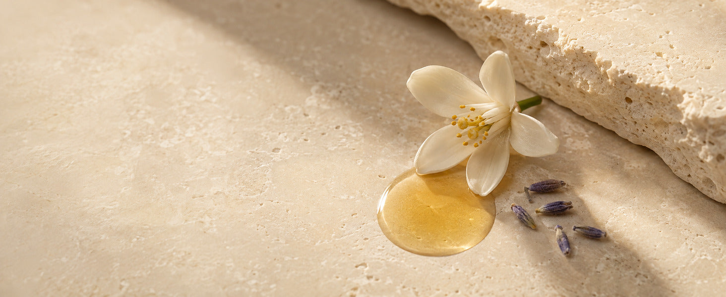 Editorial Floral Squalane oil with neroli and lavender on warm travertine