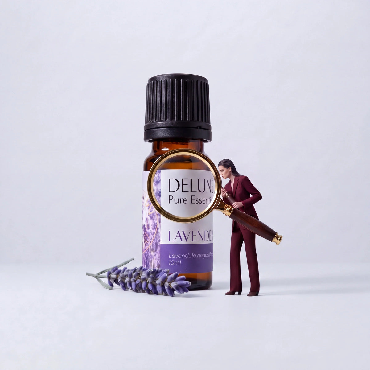 Ética: uma mulher examina com uma lupa um frasco gigante de óleo essencial puro de lavanda Delune