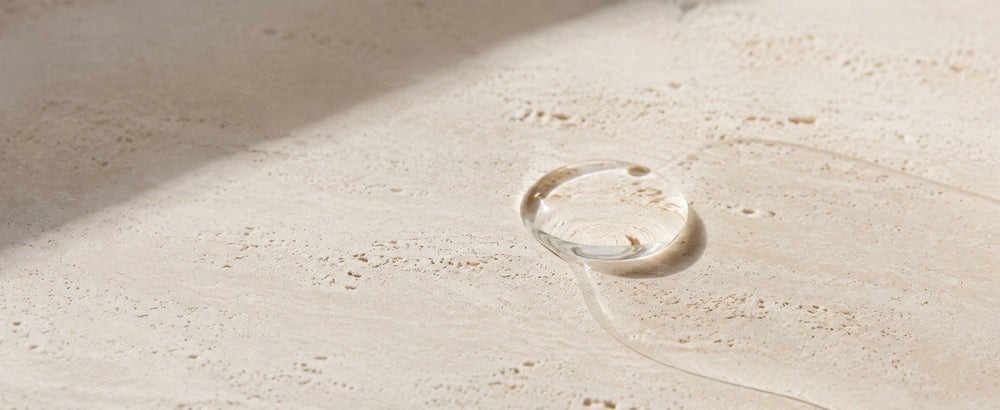 Editorial Pure Squalane formula texture on warm ivory limestone