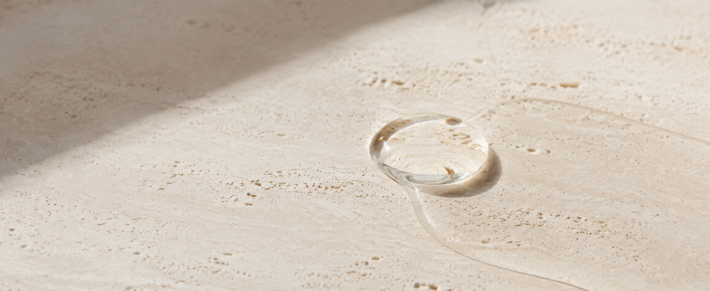 Editorial Pure Squalane formula texture on warm ivory limestone